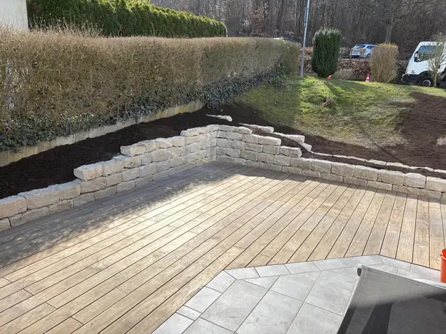 Holzterrasse mit Natursteinmauer aus Jurakalkgestein
