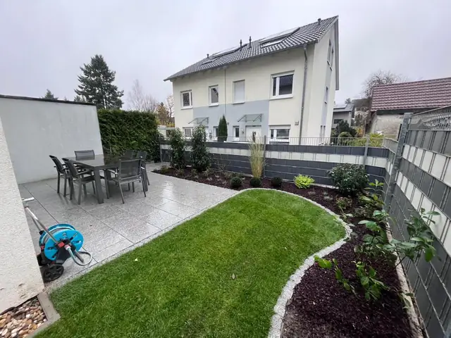 Neu angelegter Garten im Granitstil mit Rasen und Beeten